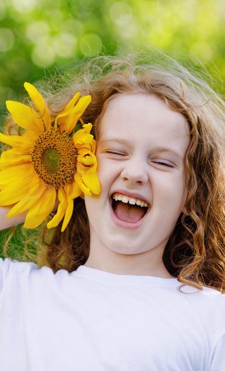 girl with sunflower near face