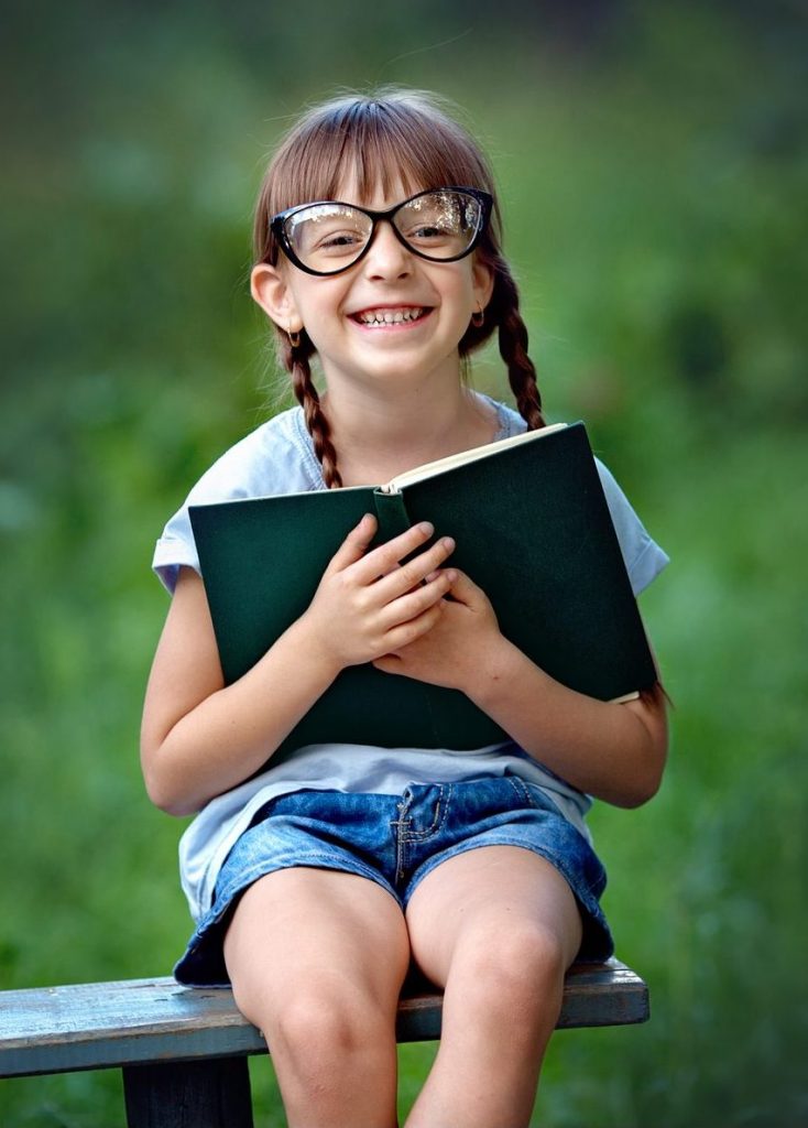 girl with plaits reading book