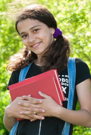 Teen smiling holding a book