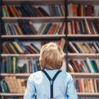 boy looking at shelves of books
